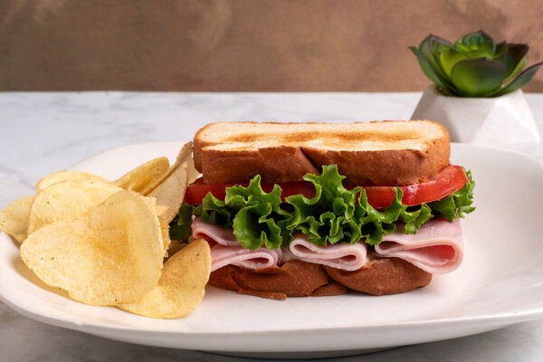  ветчина с салатом и помидорами на поджаренном белом хлебе, подаваемом с картошкой фри