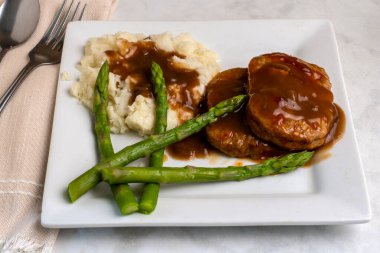 salisbury steak  served with mashed potatoes and  asparagus