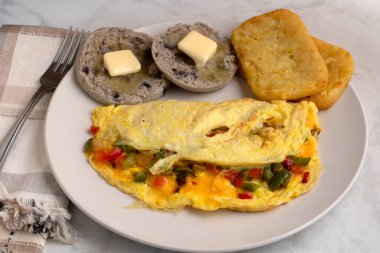 eppers and onions omelette  with hash browns and english muffins