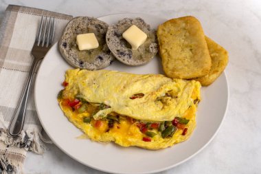 eppers and onions omelette  with hash browns and english muffins