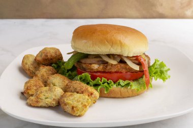 Sebzeli burger üstü soğanlı, biberli ve sebzeli patates ile servis edilen mantarlı., 