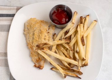  Fırında pişmiş mezgit ve patates kızartması.