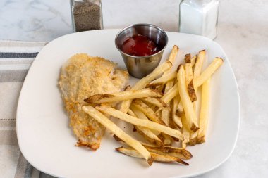  Fırında pişmiş mezgit ve patates kızartması.