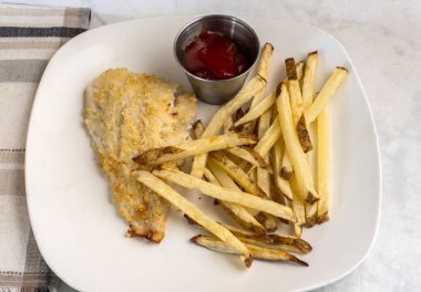  Fırında pişmiş mezgit ve patates kızartması.