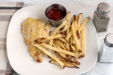  Fırında pişmiş mezgit ve patates kızartması.