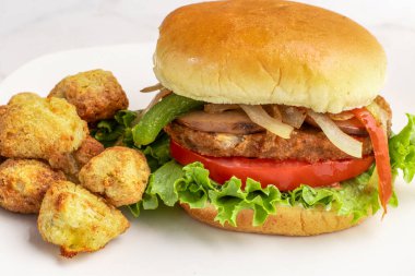 Sebzeli burger üstü soğanlı, biberli ve sebzeli patates ile servis edilen mantarlı., 