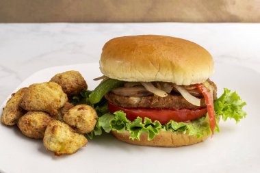 Sebzeli burger üstü soğanlı, biberli ve sebzeli patates ile servis edilen mantarlı., 