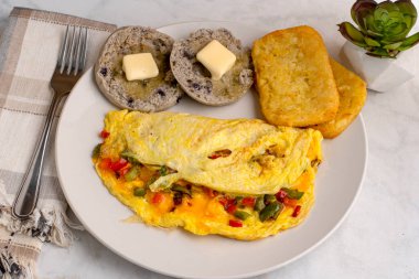 eppers and onions omelette  with hash browns and english muffins