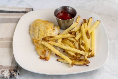  Fırında pişmiş mezgit ve patates kızartması.