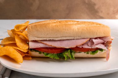 kıvırcık salata ve domatesli jambon, yanında da barbekü patates cipsi.