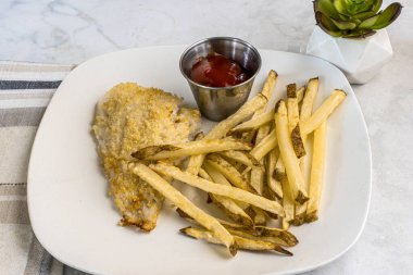  Fırında pişmiş mezgit ve patates kızartması.