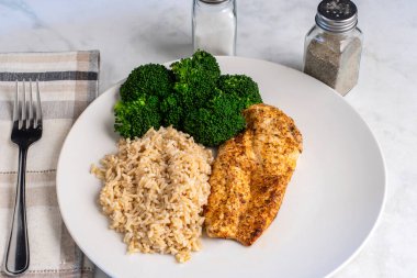 kahverengi pirinç ve brokoli ile servis edilen tavuk göğsü.