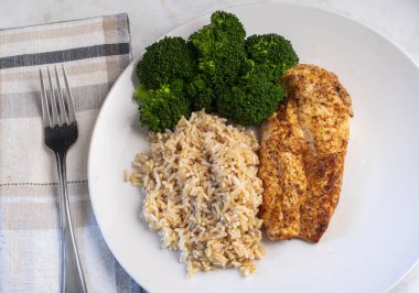 kahverengi pirinç ve brokoli ile servis edilen tavuk göğsü.