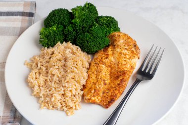 kahverengi pirinç ve brokoli ile servis edilen tavuk göğsü.