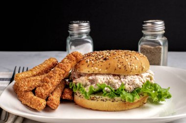 Marullu tavuk salatası, susamlı çörek ve yanında patates kızartması.