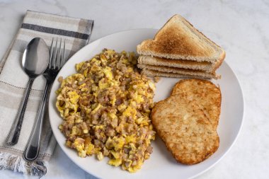 Çırpılmış yumurta, mısır sığır eti ve patates kızartmasıyla karıştırılmış..