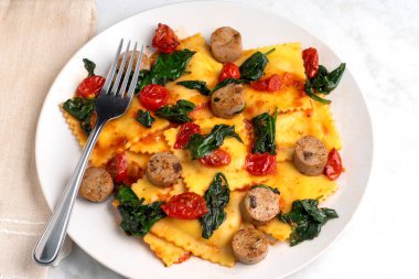 Peynirli ravioli tavuklu ve sotelenmiş domatesli ve ıspanaklı.