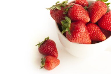 Red strawberries in a white cup isolated on white background