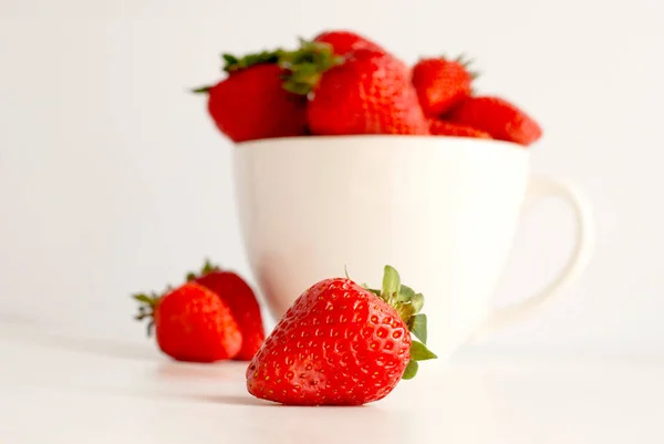 Red strawberries in a white cup isolated on white background — Zdjęcie stockowe