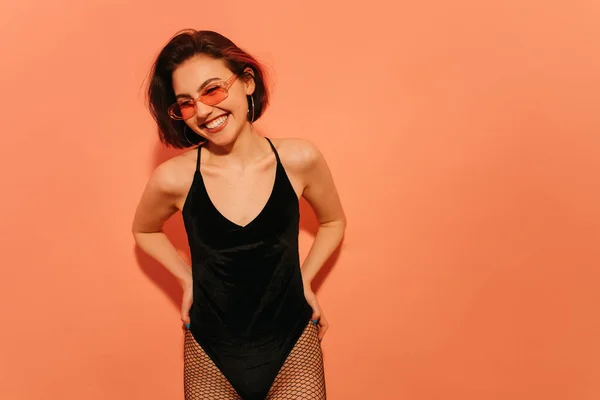 Smiling Young Woman Sunglasses Black Bodysuit Fishnet Tights Posing Orange — Stock Photo, Image