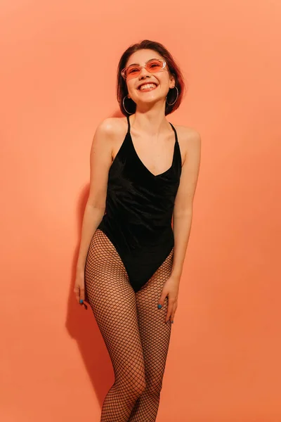 Smiling Young Woman Posing Black Bodysuit Fishnet Tights Orange Background — Stock Photo, Image