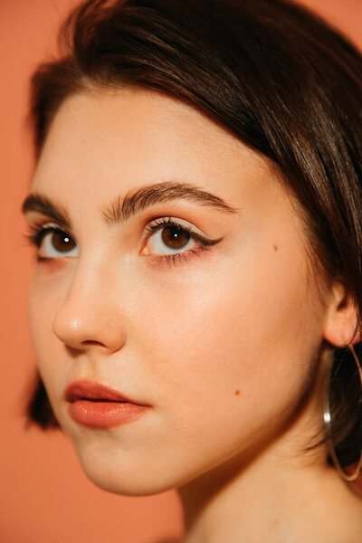 крупным планом лицо молодой женщины с блестками летних кошачьих глаз макияж изолирован на апельсин