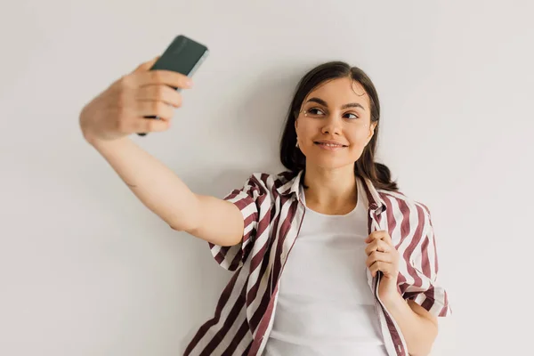 Positive Young Woman Striped Shirt Taking Selfie Smartphone Grey Background — Stock Photo, Image