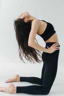 Ermeni bir kadının beyaz deve pozuyla yoga yapması.