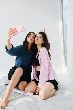Ermeni kadın yatak odasında selfie çekerken arkadaşına boğa boynuzu yapıyor.