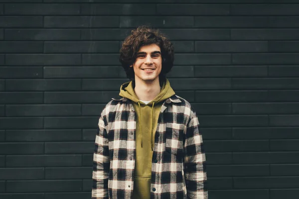 Young Curly Man Looking Camera Black Brick Wall — Stock Photo, Image