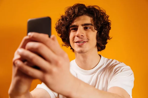 Smiling Man Using Smartphone Blurred Foreground Orange Background — Stock Photo, Image