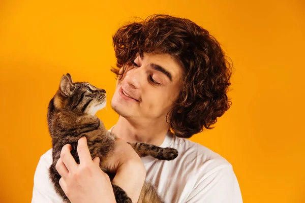 Curly Man Smiling While Looking Cat Isolated Orange — Stock Photo, Image