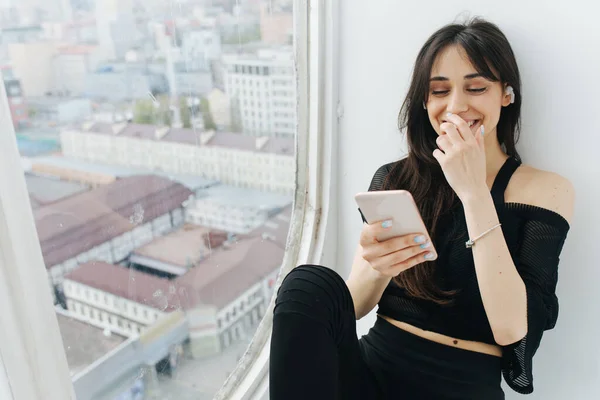 Happy Armenian Woman Covering Mouth Hand While Using Smartphone Window — Stock Photo, Image
