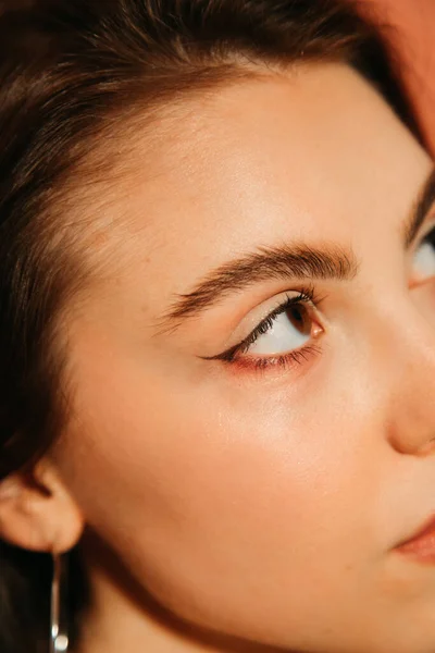 Gros plan de jeune femme visage avec des yeux de chat d'été maquillage isolé sur orange — Photo de stock