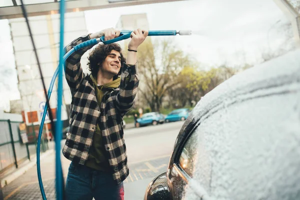 Carro de limpeza de motorista positivo com detergente em lavagem de auto-serviço — Fotografia de Stock
