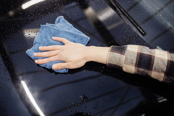 Ausgeschnittene Ansicht eines Mannes mit Lappen, der schwarzes Auto reinigt — Stockfoto