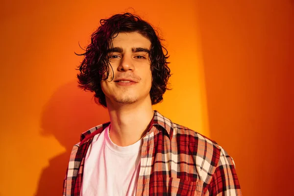 Curly man with wet hair looking at camera on orange background — Stock Photo