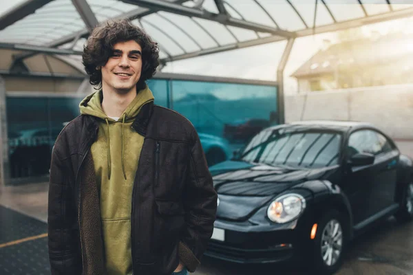 Fröhlicher Mann blickt in Kamera neben verschwommenem Auto auf Selbstbedienungswaschanlage — Stockfoto