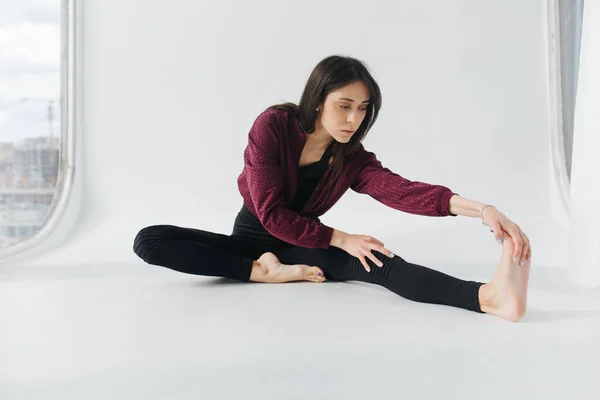 Brunette arménienne femme pratiquant assis plier vers l'avant pose sur le plancher blanc — Photo de stock