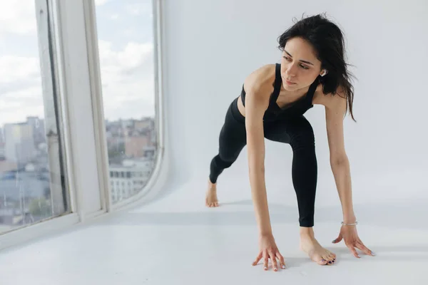 Jovem mulher arménia em sportswear preto praticando ioga em pose lunge — Fotografia de Stock