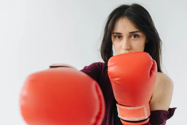 Giovane donna armena in guanti da boxe rossi guardando la fotocamera su sfondo bianco — Foto stock