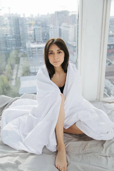 Brunette armenian woman looking at camera near window in bedroom — Stock Photo