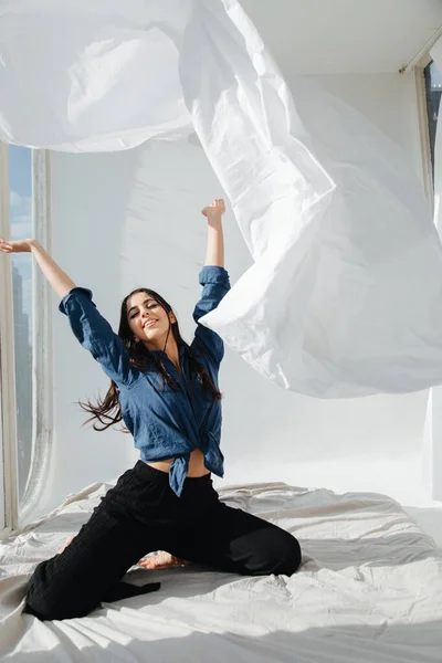 Alegre mulher arménia vomitando lençol branco no quarto — Fotografia de Stock