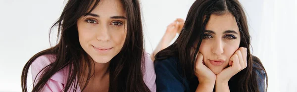 Femme arménienne positive regardant la caméra près de l'ami ennuyé sur fond blanc, bannière — Photo de stock