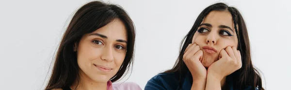 Sorrindo mulher arménia olhando para a câmera perto amigo ofendido isolado no branco, banner — Fotografia de Stock