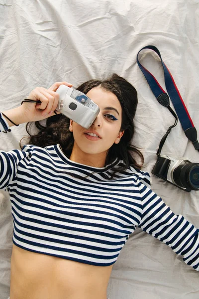 Top view of pretty armenian woman taking photo on digital camera — Stock Photo