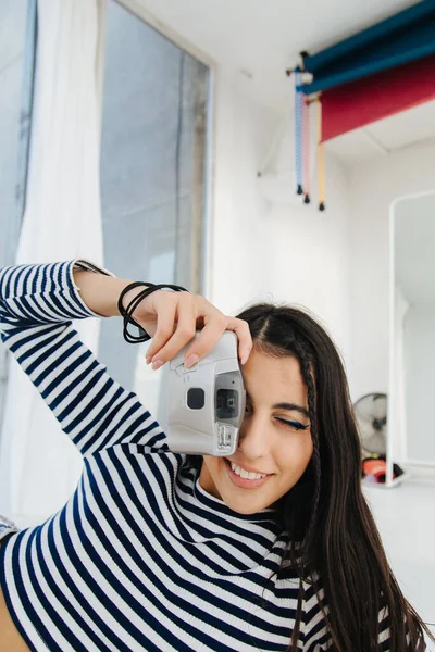 Smiling armenian woman in striped pullover taking photo on digital camera — Stock Photo