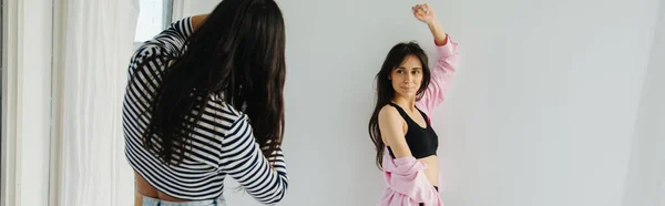 Vue arrière de la femme brune faisant session photo d'un ami arménien debout près du mur blanc, bannière — Photo de stock