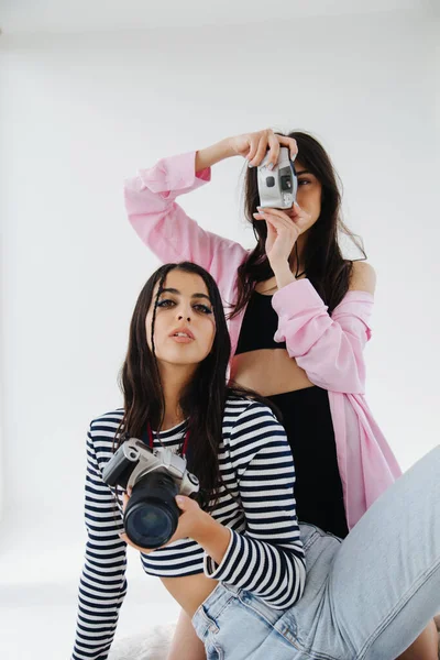 Donne armeniane giovani ed eleganti con fotocamere digitali su sfondo bianco — Foto stock