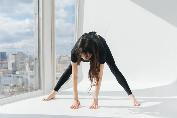 Barefoot armenian woman practicing pyramid pose near window — Stock Photo